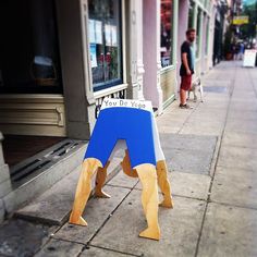 there is a blue and yellow dog house on the sidewalk