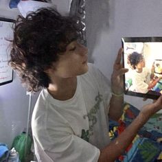 a young boy is holding up an image of himself