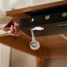 a person holding a cell phone under a table