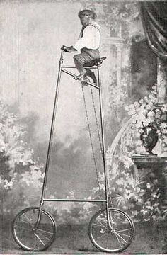 an old photo of a man sitting on top of a bicycle with flowers in the background