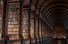 an old library filled with lots of wooden bookshelves and arched doorways that lead into the ceiling