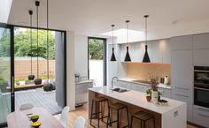 an open kitchen and dining area with sliding glass doors leading to the outside decking