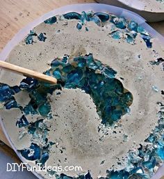 a blue and white dish with some paint on it next to a wooden spatula