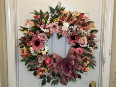 a wreath on the front door decorated with flowers