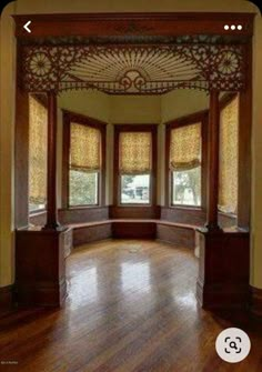 an empty room with wooden floors and windows