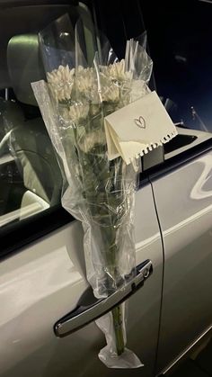 a bouquet of flowers sitting on top of a car door handle