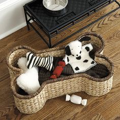 a dog bed with stuffed animals in it on the floor next to a record player