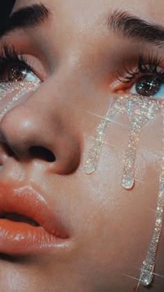 a close up of a woman's face with glitter on her eyes and eyelashes