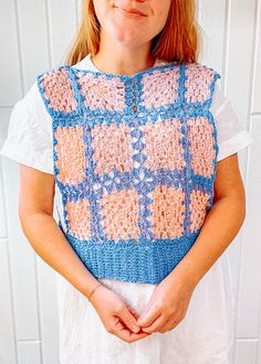 a woman wearing a crochet top with her hands in her pockets