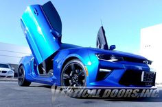 a blue sports car with its doors open