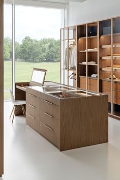 a large open closet with wooden cabinets and drawers