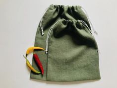 a green bag with two different colored peppers in it