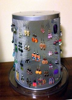 there is a large metal container with many earrings on the top and bottom half of it