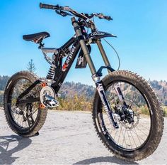 a dirt bike parked on the side of a road in front of some hills and trees