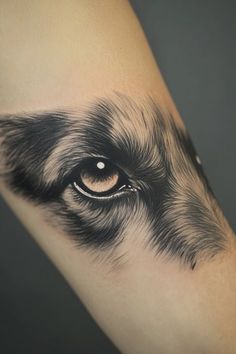 an eye is shown on the arm of a woman's leg, with black and white ink