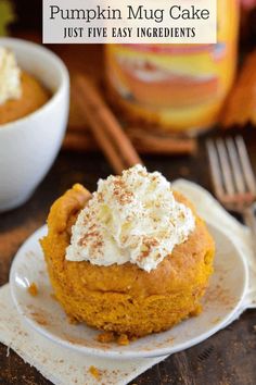 pumpkin mug cake on a white plate with whipped cream and cinnamon sprinkles