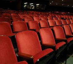 rows of red chairs in an empty auditorium