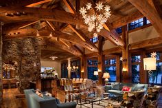 a living room filled with furniture and a chandelier hanging from the ceiling over a fire place