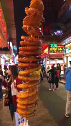 a large stack of donuts sitting on top of each other in front of people