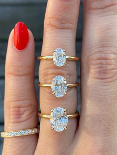 a woman's hand with three different rings on it