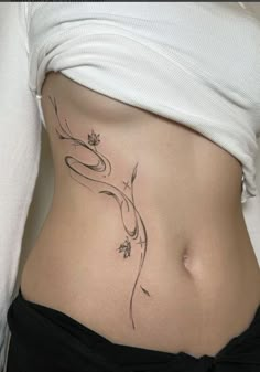 a woman's stomach with a flower tattoo on her belly and the bottom part of her abdomen