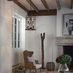 a living room filled with furniture and a chandelier hanging from the ceiling next to a fire place