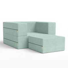 two light green couches sitting next to each other on a white surface with no one in it