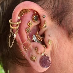 a close up of a person's ear with many different types of jewelry on it