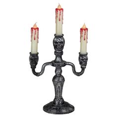 three candles are lit with blood on the top and bottom of each candle holder, as if they were dripping from them