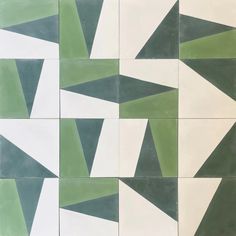 a green and white tiled wall with different shapes