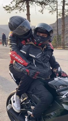 two people riding on the back of a motorcycle