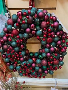 a christmas wreath with ornaments hanging from it