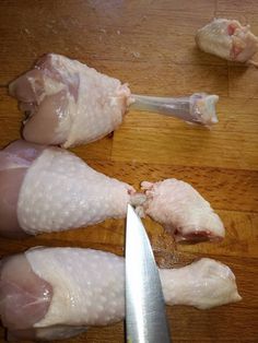 raw chicken being cut into pieces with a knife