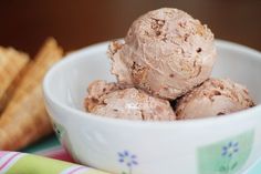 a white bowl filled with ice cream next to crackers and a napkin on a table