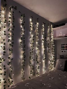 a bedroom decorated with lights and ivy vines hanging on the wall, along with a bed