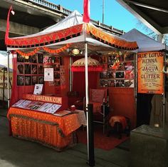 an orange and white tent sitting under a bridge