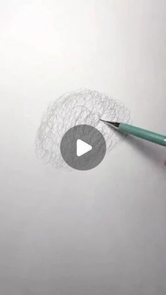 someone is holding a pencil and drawing on the paper with crochet doily