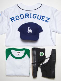 a baseball cap, t - shirt, and sneakers are laid out on a white surface