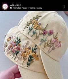 someone is showing off their new hat with embroidered flowers on the front and back side