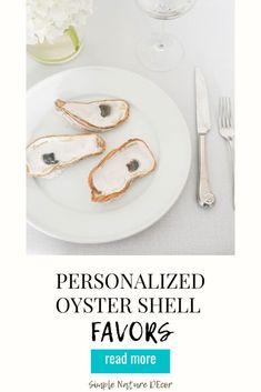 personalized oyster shell favors on a white plate with silverware and flowers in the background