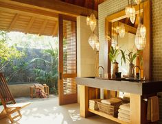 a bathroom with a sink, mirror and hanging lights in it's center area