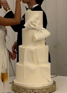 a bride and groom are kissing in front of a wedding cake