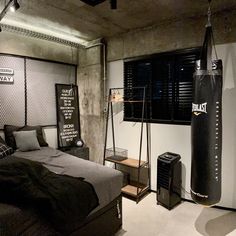 a bed room with a neatly made bed and punching bag