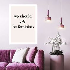 a purple couch sitting next to a white vase with flowers in it and a quote on the wall above it