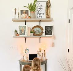 two children sitting at a desk with pictures and candles