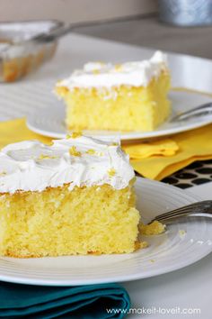 two slices of yellow cake with white frosting sitting on plates next to each other