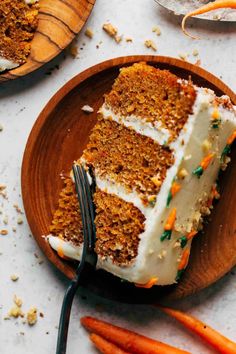 a slice of carrot cake on a wooden plate