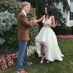 a woman in a wedding dress standing next to a man