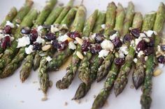 asparagus with cranberries, pine nuts and feta cheese on top