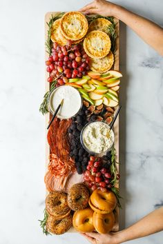 a wooden platter filled with different types of food on top of a marble counter